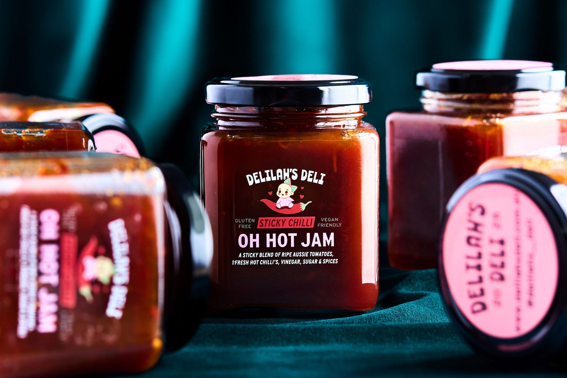 Jars of Delilah's Deli hot jam on a green background