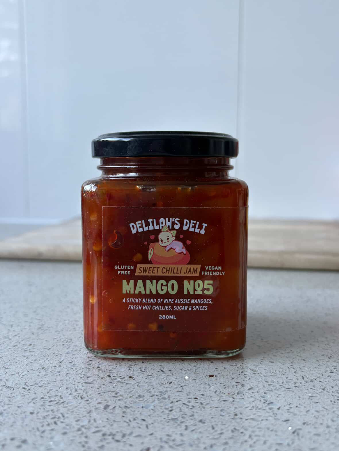 Jar of Delilah's Deli Mango No.5 sweet chili jam on a light surface with a white background